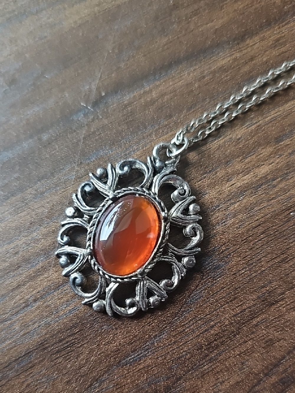 Magic silver-tone filigree pendant necklace with warm amber-like cabochon